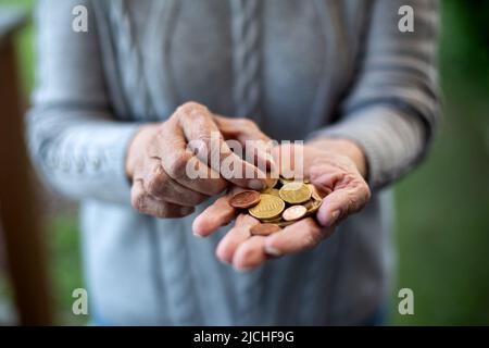 close-up of an older womans hand holding coins and counting Stock Photo