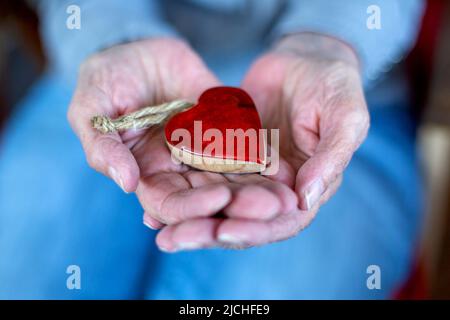 Older woman's hands holding a wooden cross rosery Stock Photo - Alamy