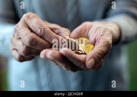 close-up of an older womans hand holding coins and counting Stock Photo