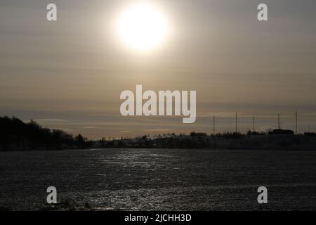 Sunset over icy terrain covered by snow; start of the polar night in Murmansk, Russia Stock Photo