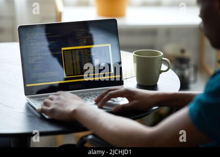 Close up of young man with disability writing code on computer screen, copy space Stock Photo