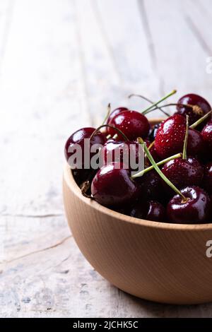 Cherries in a bowl on wooden table Stock Photo