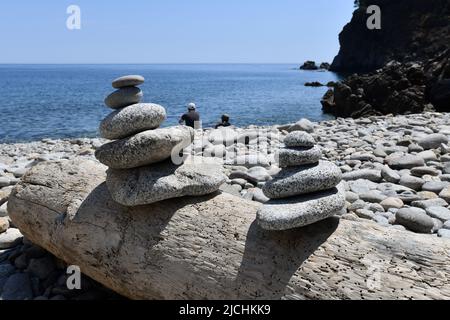 Stone pile or rock stack on pebbled beach Catalonia, Spain Stock Photo