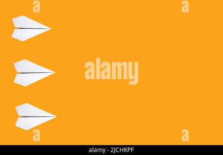 Banner with white origami planes on orange background. Paper folding art. Copy space. High quality photo Stock Photo