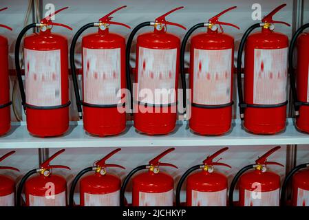 Red fire extinguishers stand in a row. Stock Photo