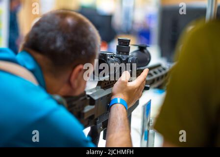 Man aiming at an optical sniper rifle sight. Stock Photo