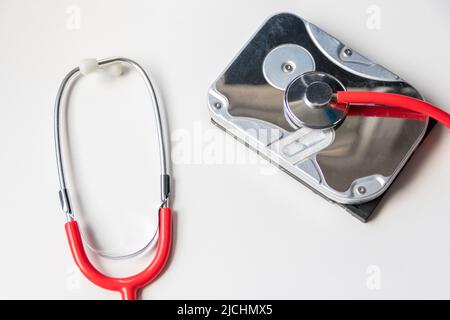 Red stethoscope with internal hard disk drive hdd contains health record and sensitive patient data with hardware doctor checkup and rest data breach Stock Photo