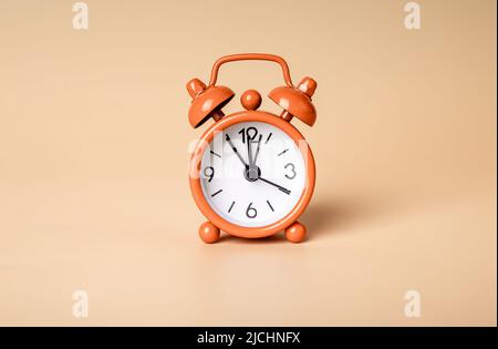Retro styled bright orange alarm clock on background, photo Stock Photo