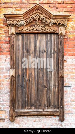 Installation in the form of an old window on a red brick wall Stock Photo