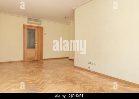 Empty living room with oak parquet flooring with matching wooden doors, air conditioner and plaster molding ceilings Stock Photo