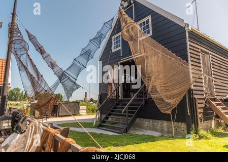 Enkhuizen, Netherlands, June 2022. Traditional fishing boats and nets hanging out to dry at the Zuiderzee Museum in Enkhuizen. High quality photo. Sel Stock Photo