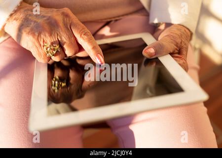 Close up of unrecognizable elderly person using a digital tablet. Concept of old people and new technologies. Stock Photo