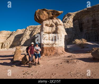 A couple stops for a photograph at The Toadstools in Grand Staircase Escalante, UT. USA.  Numerous rock formations resembling mushrooms or toadstools. Stock Photo