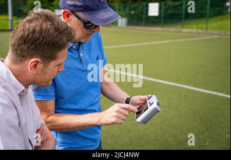 Crew / pilot operating a DJI Mini 3 Pro drone (UAV) using remote control Stock Photo