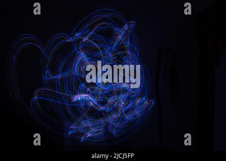 Light painting Abstract colorful irregular lines or patterns on black background with long exposure. Stock Photo
