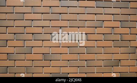 Brick wall made of modern facing bricks. Brick wall made of facing bricks, close-up. Background for text. The wall is made of bricks. New style. Stock Photo
