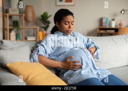 Pregnant African Woman Suffering From Pain Having Spasm At Home Stock Photo