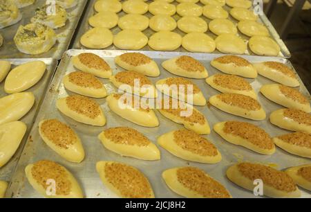 Unbaked puff pastries (Pogaca) in the baker factory. Stock Photo
