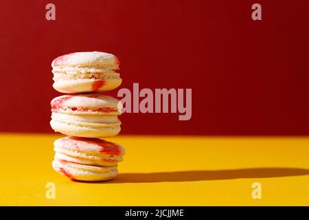 Stacked Raspberries Macaroon with White and Red Color on Red Yellow Background, Selected Focus Stock Photo