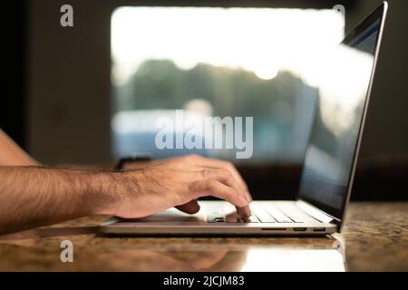 Hands of a business man professional user professional worker using typing on laptop keyboard sit at home office desk working online Stock Photo