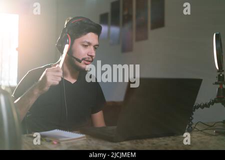 Close up of young man using laptop, writing, taking notes, watching webinar, training, participating in internet classes, motivated positive student s Stock Photo
