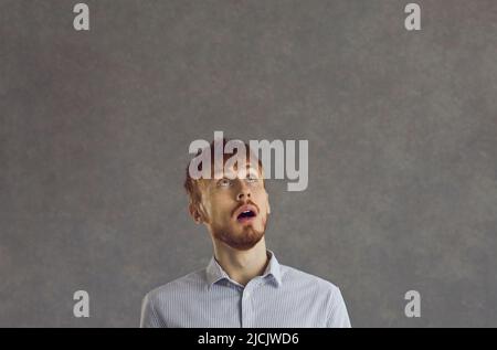 Portrait of a young man looking up at something with a surprised face expression Stock Photo