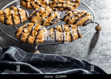 Chip cookies with peanuts and chocolate strips on a black table. Stock Photo