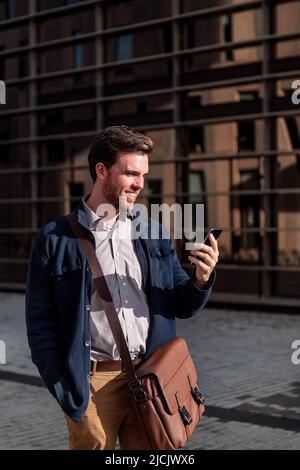 businessman looking phone by an office building Stock Photo