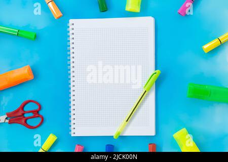 Felt tip pens, scissors and notepad for drawing or writing. Stationery on blue background. Concept back to school, education. Copy space Stock Photo