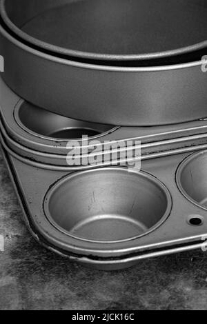 Baking trays and cake tins on a black stone background. Cooking utensils concept Stock Photo