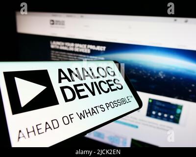 Mobile phone with logo of semiconductor company Analog Devices Inc. (ADI) on screen in front of website. Focus on center of phone display. Stock Photo