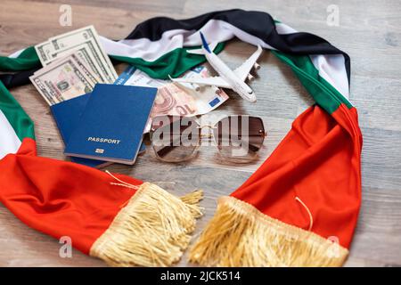 Flag of United Arab Emirates with passport and toy airplane on wooden background. Flight travel concept Stock Photo