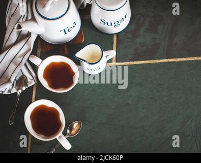 Two cups of tea, teapot, milk on table, copy space. Stock Photo