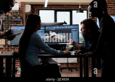 Production department team gathered around 3D artist engineer trying to solve geometry problem. Digital engineering experts collaborating in order to develop advanced scene. Stock Photo