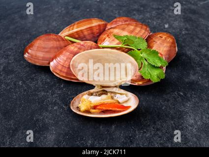 open en closed clams with shellfish isolated on black background. Stock Photo