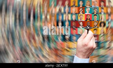 Hand with magnifying glass searching human resources among diverse business people as career and team concept Stock Photo