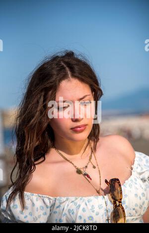 Fashionably dressed teenegers girl relaxing on the waterfront promenade Stock Photo