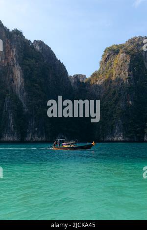 Long tail boat cruising through the turquoise waters of Koh phi phi leh lagoon in Thailand Stock Photo