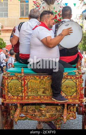 Traditional Sicilian folk musicians with their gaily decorated horse and cart - a 'carrettu sicilianu' - at a local festival in Maletto, Sicily Stock Photo