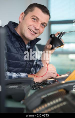 happy computer engineer working on broken console Stock Photo