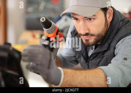 close view of workman using cordless screwdriver Stock Photo
