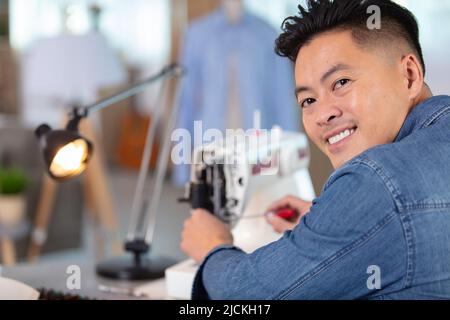 mechanic repairing industrial sewing machine Stock Photo