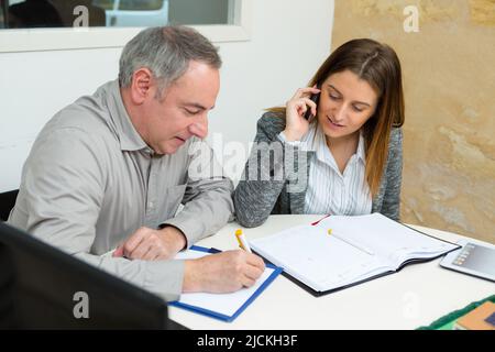 contemporary traders reading papers in office Stock Photo