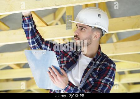 construction worker on duty in wooden house frame Stock Photo