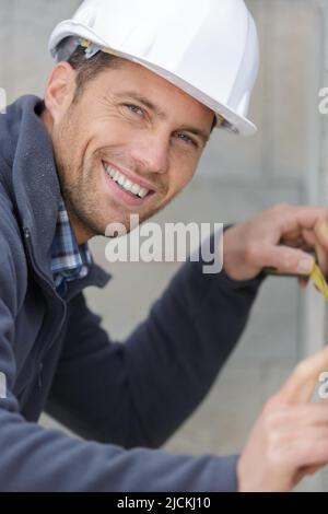 happy engineer use measuring tape in work site Stock Photo