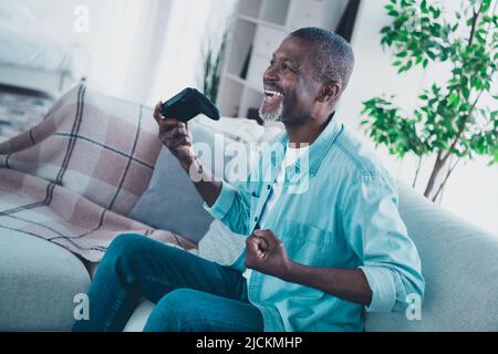 Profile side photo of good mood overjoyed male addicted to cybersport playing video games using playstation Stock Photo