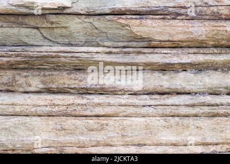 Relief of large gray rock, multi-storey layered rough sedimentary rocks. Natural big stone background, close up texture of layers of horizontal stone Stock Photo