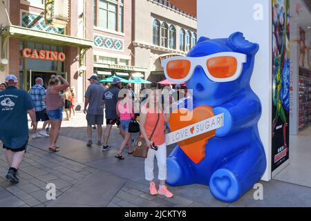 Nevada USA 05-09-21 A tourist poses next to a giant Gummy Bear symbol of the famous I LOVE SUGAR store located in The LINQ Promenade Las Vegas Stock Photo