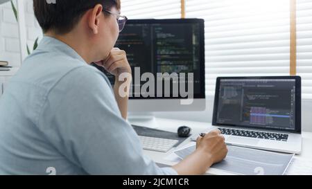 Software development concept, Male programmer read data code to thinking about developing website. Stock Photo