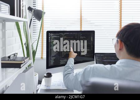 Software development concept, Male programmer checking data codes on document and computer screen. Stock Photo